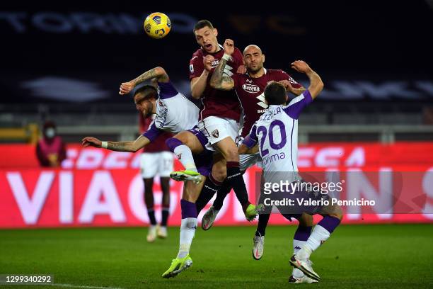Andrea Belotti and Simone Zaza of Torino clash with Cristiano Biraghi and German Pezzella of Fiorentina during the Serie A match between Torino FC...