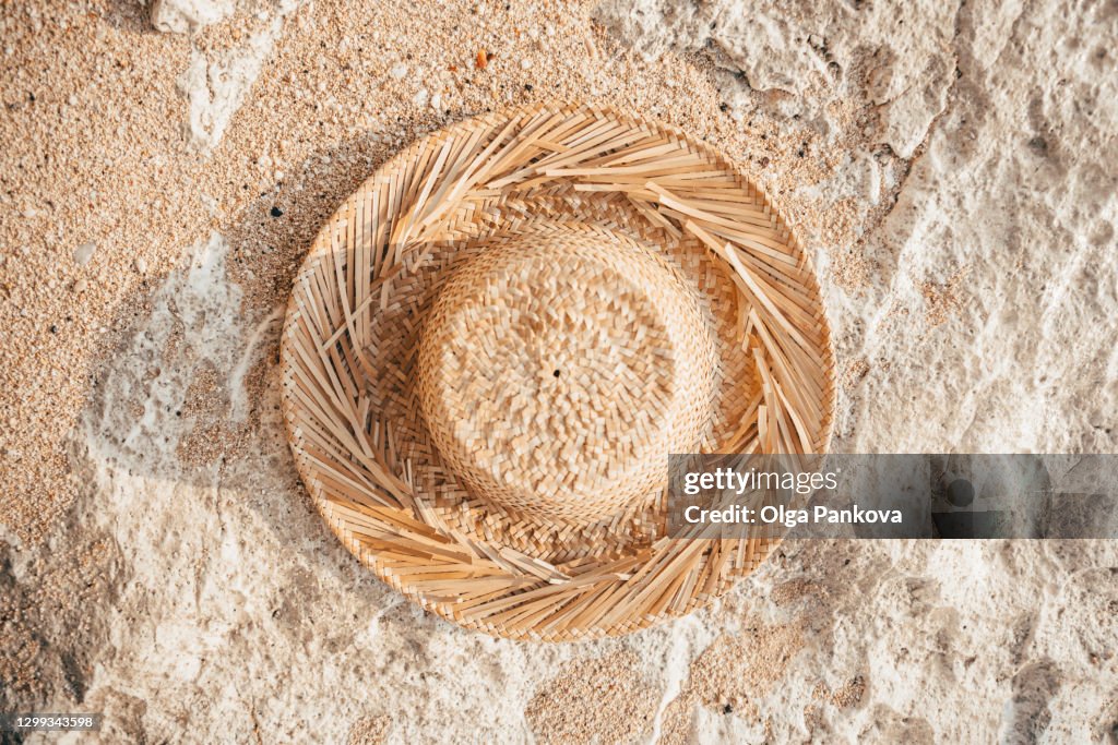 Straw hat close-up. Panama on the sand. Vacation concept. Beach mood. Background in warm colors. Copy space.
