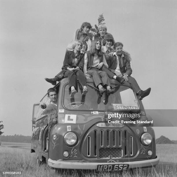 Group of hippies on the roof of a Morris van in the countryside, UK, October 1967. The 'Destination' sign in the window has been left blank, but they...
