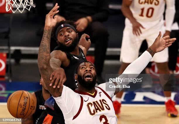 Andre Drummond of the Cleveland Cavaliers is fouled as he has for the net by Mitchell Robinson of the New York Knicks in the first quarter at Madison...