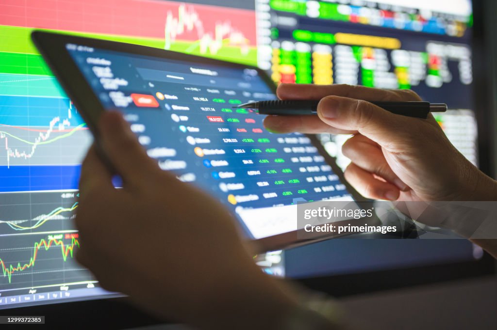 Business Investor buying stock ,cryptocurrency,bitcoin, through a mobile app and analysis with chart after coronavirus crisis stockmarket going to uptrend market stage