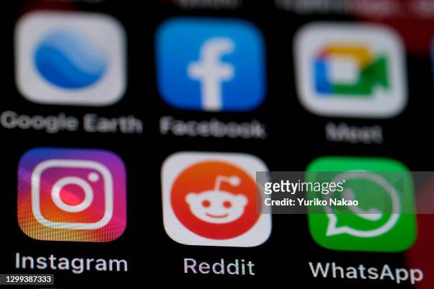In this photo illustration, the logo of Reddit, a social news aggregation is pictured along with other apps, including Google Earth, Facebook, Google...