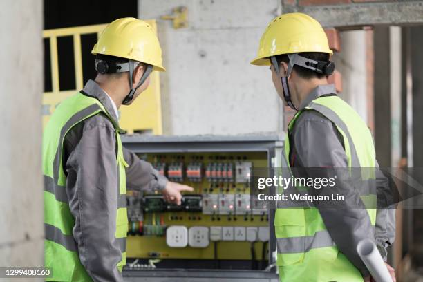 workers inspecting distribution boxes - electrical panel box fotografías e imágenes de stock