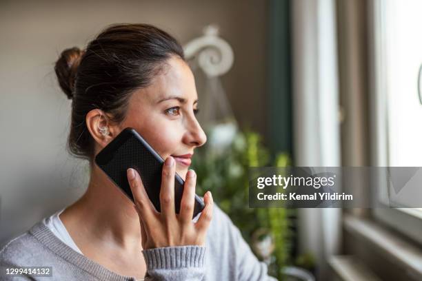 young adult woman did not expect hearing aid at this age - orelha imagens e fotografias de stock