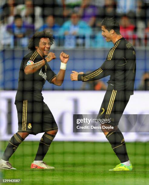 Cristiano Ronaldo of Real Madrid celebrates with Marcelo after scoring his third goal during the La Liga match between Malaga CF and Real Madrid CF...