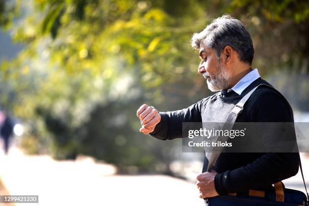 businessman checking time on wristwatch - top priority stock pictures, royalty-free photos & images