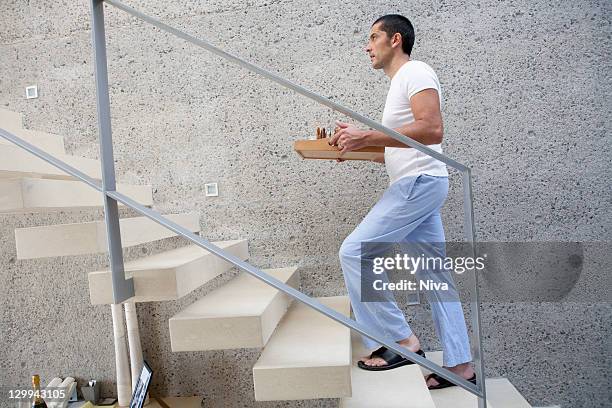 man carrying tray of food up stairs - tray stockfoto's en -beelden