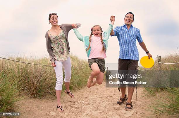 family walking together on beach - dorset uk stockfoto's en -beelden