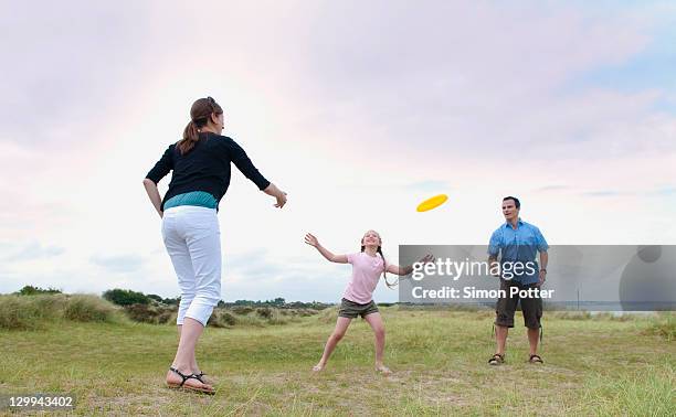 familia jugando con frisbee al aire libre - frisbee fotografías e imágenes de stock
