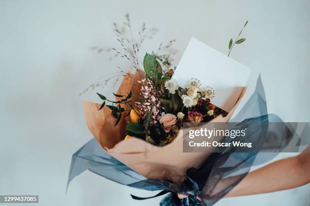 hand holding flower bouquet with blank greeting card - bouquet stock pictures, royalty-free photos & images