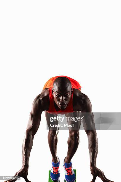 runner crouched en línea de salida - atletismo en pista masculino fotografías e imágenes de stock