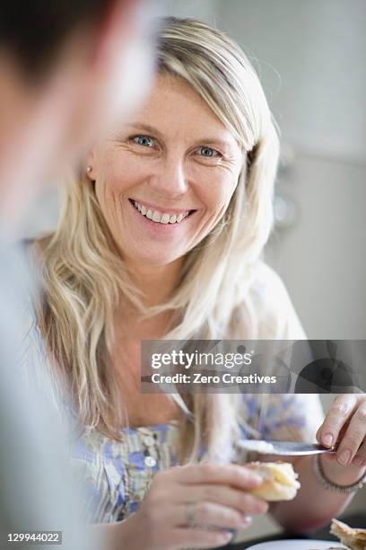mujer sonriente untar de mantequilla pan - untar de mantequilla fotografías e imágenes de stock