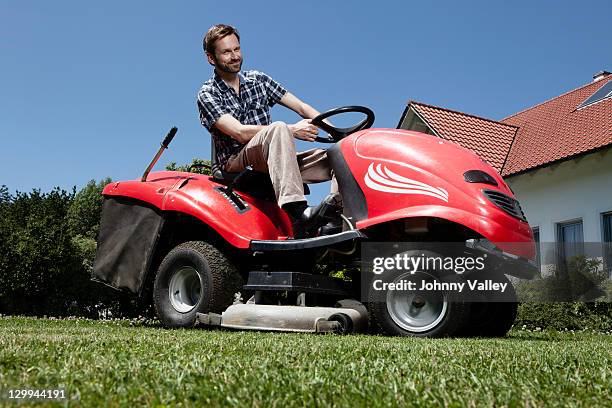 man riding lawn mower in backyard - rasenmäher stock-fotos und bilder