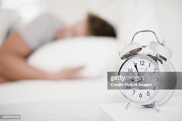 close up of alarm clock on bedside table - alarm clock close up stock pictures, royalty-free photos & images