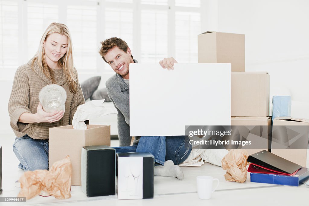 Couple unpacking boxes in new home