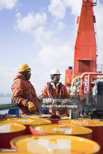 workers standing on oil rig - oil barrels ストックフォトと画像