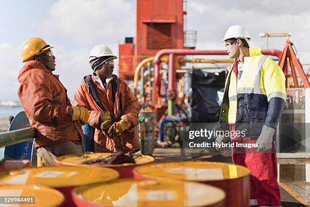 travailleurs parlant sur la plateforme pétrolière offshore - plateforme offshore photos et images de collection
