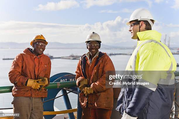 workers talking on oil rig - dockarbeiter stock-fotos und bilder
