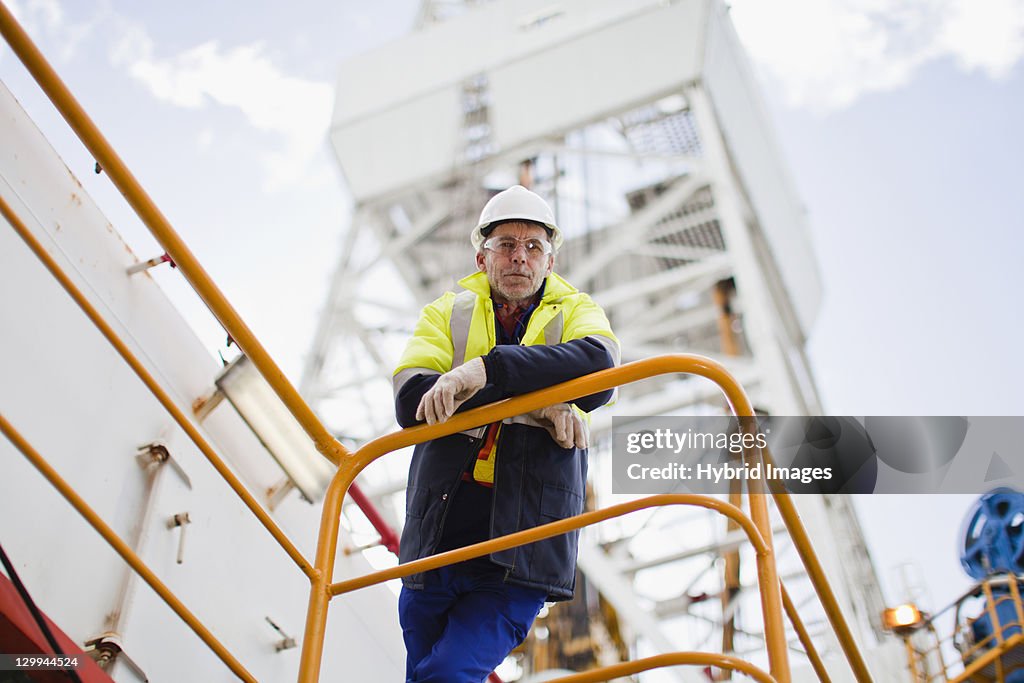 Trabajador apoyarse sobre la baranda de plataforma petrolífera