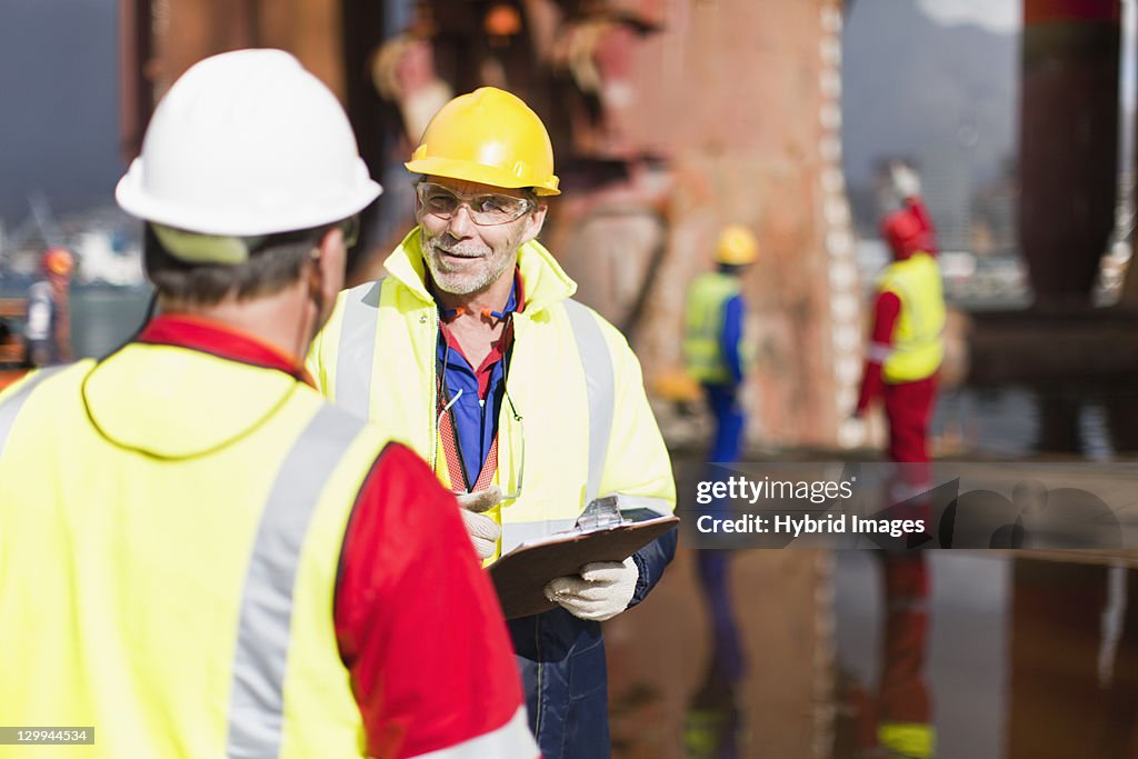 Workers talking on oil rig