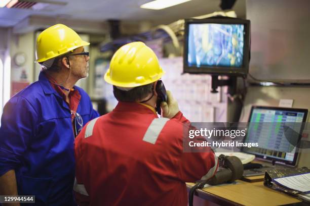 workers watching security cameras - oil rig control room stock pictures, royalty-free photos & images
