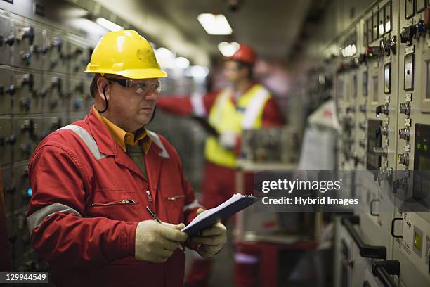 worker checking machinery - olie industrie stockfoto's en -beelden