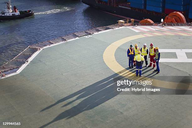 workers talking on helipad of oil rig - plataforma petrolífera imagens e fotografias de stock