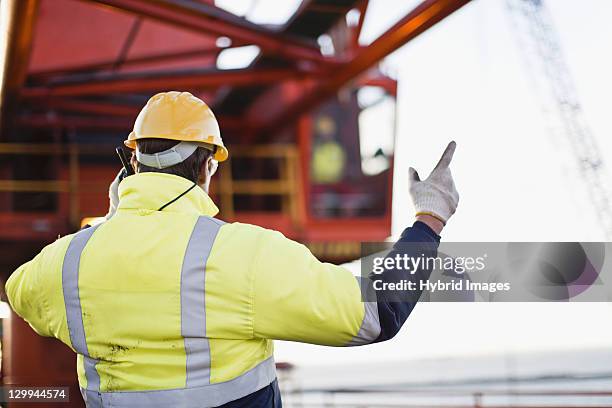 worker using walkie talkie on oil rig - offshore drilling stock pictures, royalty-free photos & images