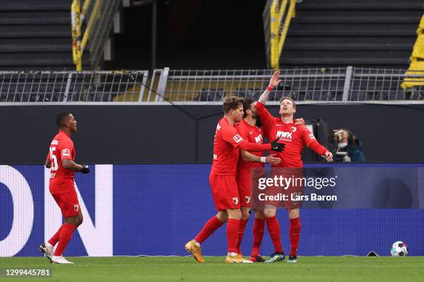 Andre Hahn of FC Augsburg celebrates with teammates after scoring his team's first goal during the Bundesliga match between Borussia Dortmund and FC...