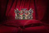 Golden crown on red velvet background Royal symbol, coronation.