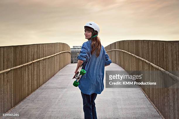 girl riding skateboard on walkway - helmet stock pictures, royalty-free photos & images