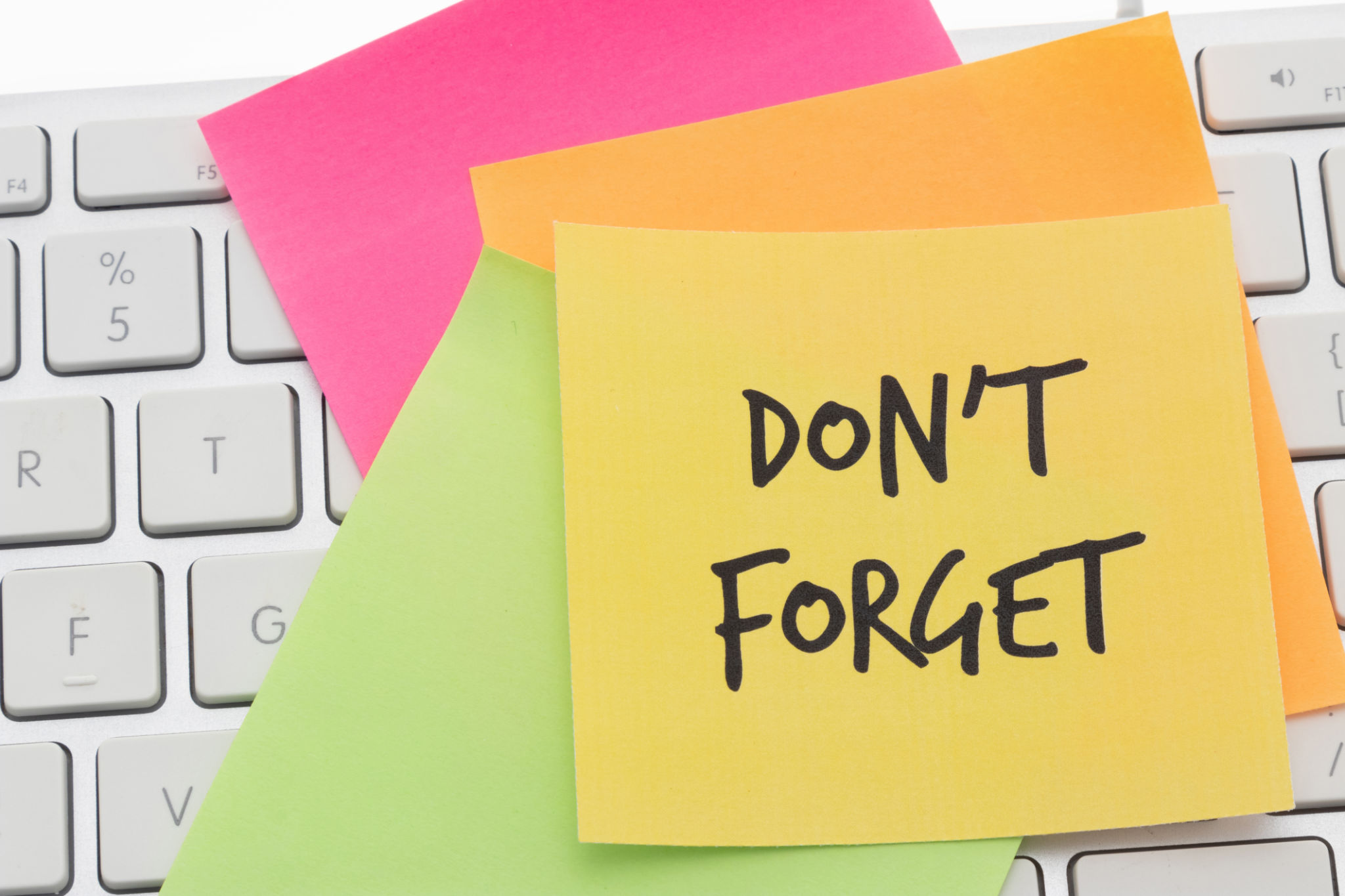 An adhesive note on a computer keyboard - Dont forget An adhesive note on a computer keyboard - Dont forget