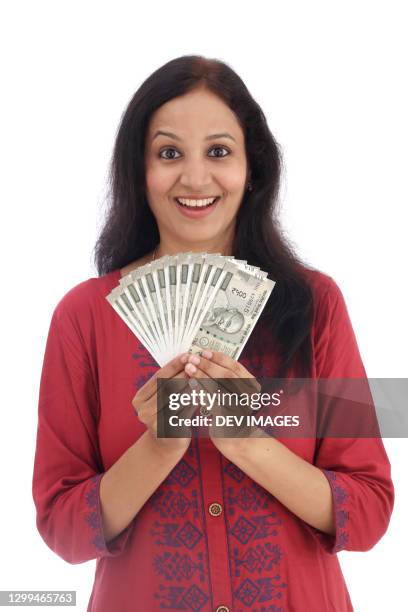 cheerful young indian woman holding currency notes - indian rupee stockfoto's en -beelden