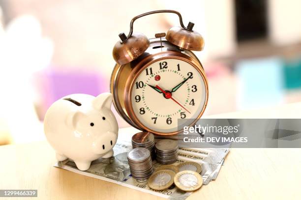 concept of time and money savings-piggy bank and indian currency notes - mutual fund stock pictures, royalty-free photos & images