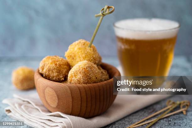 potato croquette with cheese and a glass of beer - kroket stockfoto's en -beelden