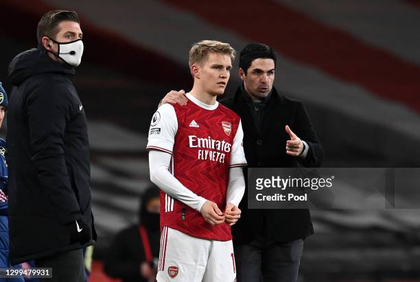 Mikel Arteta, Manager of Arsenal gives Martin Odegaard of Arsenal instructions before coming on for his debut during the Premier League match between...