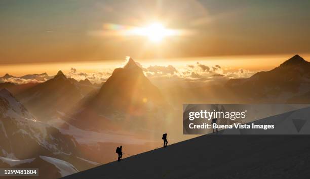climbers on a snowy ridge at sunrise - people climbing walking mountain group stock pictures, royalty-free photos & images