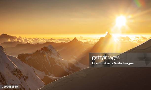 climbers on a snowy ridge at sunrise - mountain ridge stock pictures, royalty-free photos & images