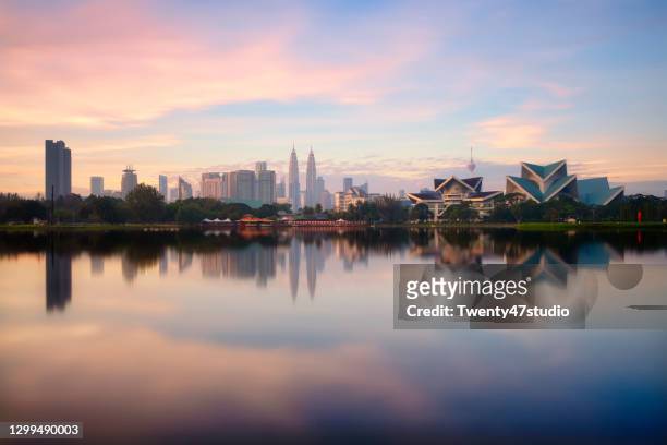 panoramic kuala lumpur cityscape reflects on lake from titiwangsa park in malaysia - kuala lumpur stock pictures, royalty-free photos & images