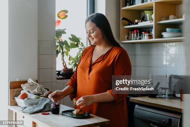 happy plus size woman preparing breakfast in the kitchen - spread joy stock pictures, royalty-free photos & images