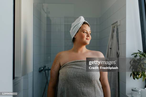 portrait of a happy  plus size woman standing in the bathroom after a relaxing shower - woman shower bath imagens e fotografias de stock