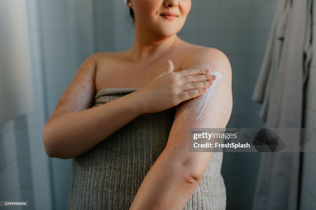 Anonyme übergewichtige Frau Anwendung Body Lotion nach der Dusche