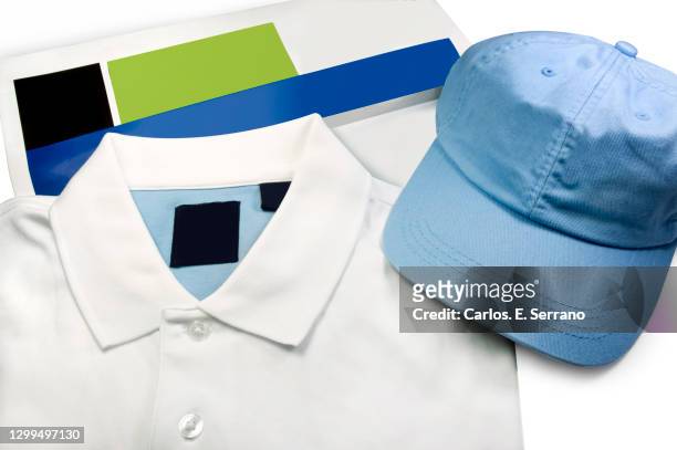 a light blue denim cap, a white golf shirt and a magazine ready for branding - golf merchandise stock pictures, royalty-free photos & images