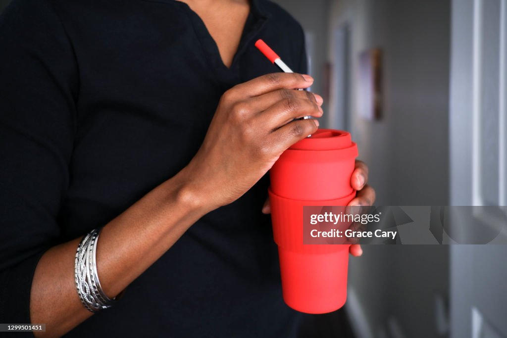 Woman Enjoys Drink Using Reusable Cup and Straw