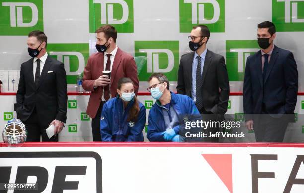 Vancouver Canucks assistant coaches Newell Brown, Chris Higgins, Jason King and Nolan Baumgartner look on from the bench during their NHL game...