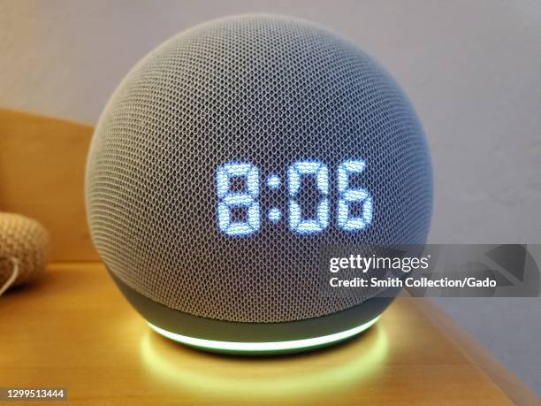 Close-up shot of the Amazon Echo Dot smart speaker with clock and Alexa on a night stand in Lafayette, California, January 22, 2021.