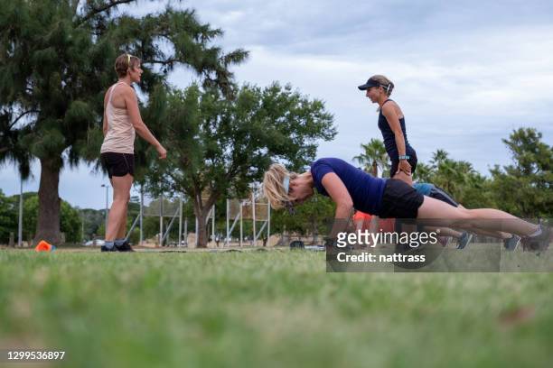 l'istruttore di fitness conduce una sessione di palestra all'aperto sui campi aperti - open workouts foto e immagini stock