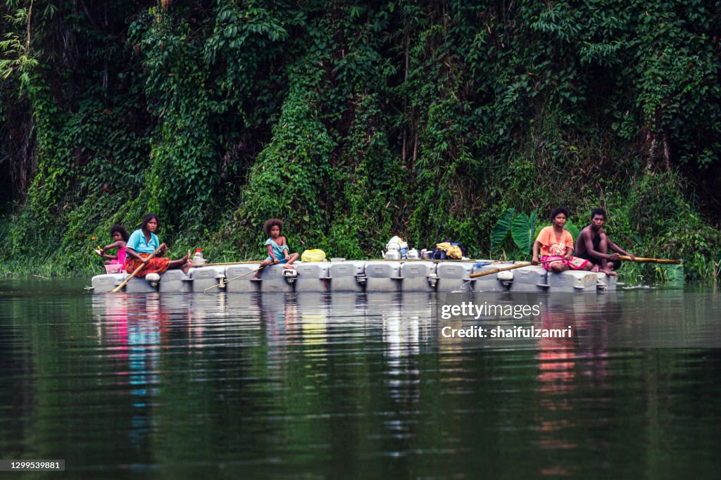 Group of local people paddling a boat going home as part of daily life on Royal Belum Rainforest Park.