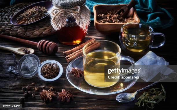 high angle close-up view of a cup of hot tea chamomile infusion on a table in a rustic kitchen - steeping stock pictures, royalty-free photos & images