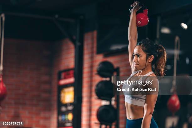 asian female doing free weights training indoors - eurasian female stock pictures, royalty-free photos & images